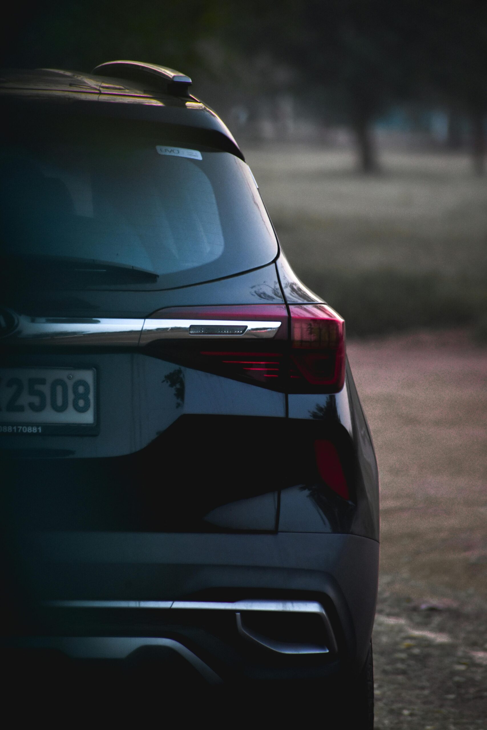 Elegant black car with stylish rear design parked outdoors, showcasing modern automotive design.